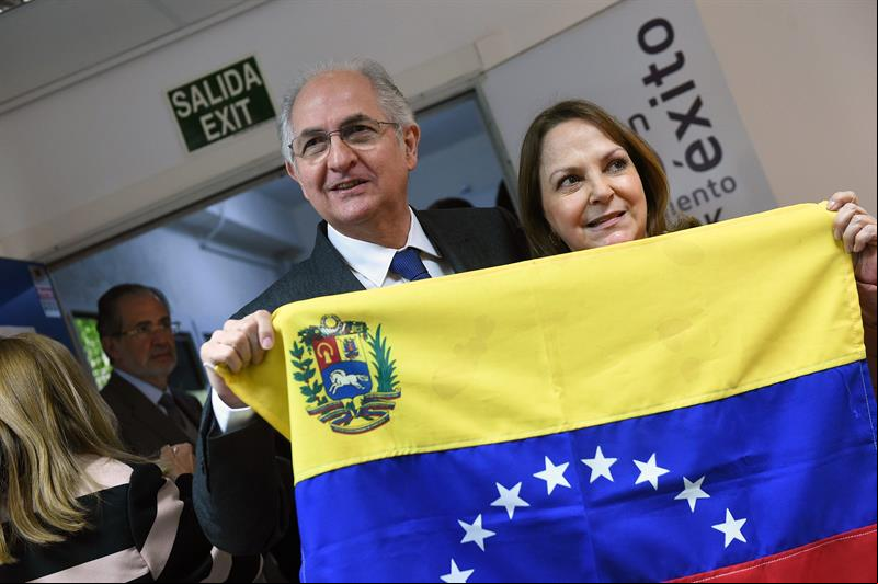 ntonio Ledezma e sua esposa Mitzy Capriles atrás da bandeira da Venezuela