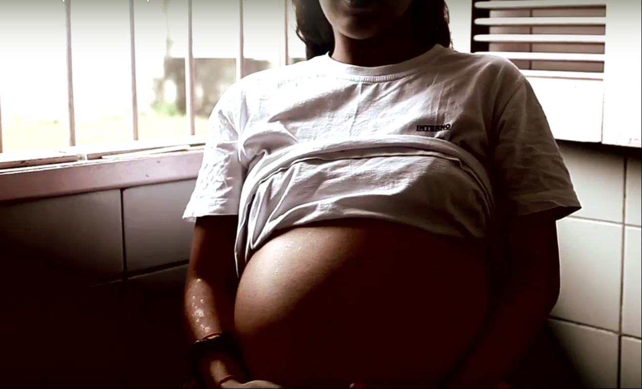 mulher grávida negra segurando a barriga